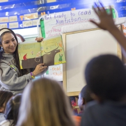 SF State student reading to children in a classroom.