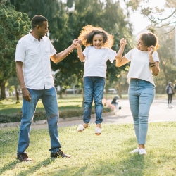 parents and jumping child in a park